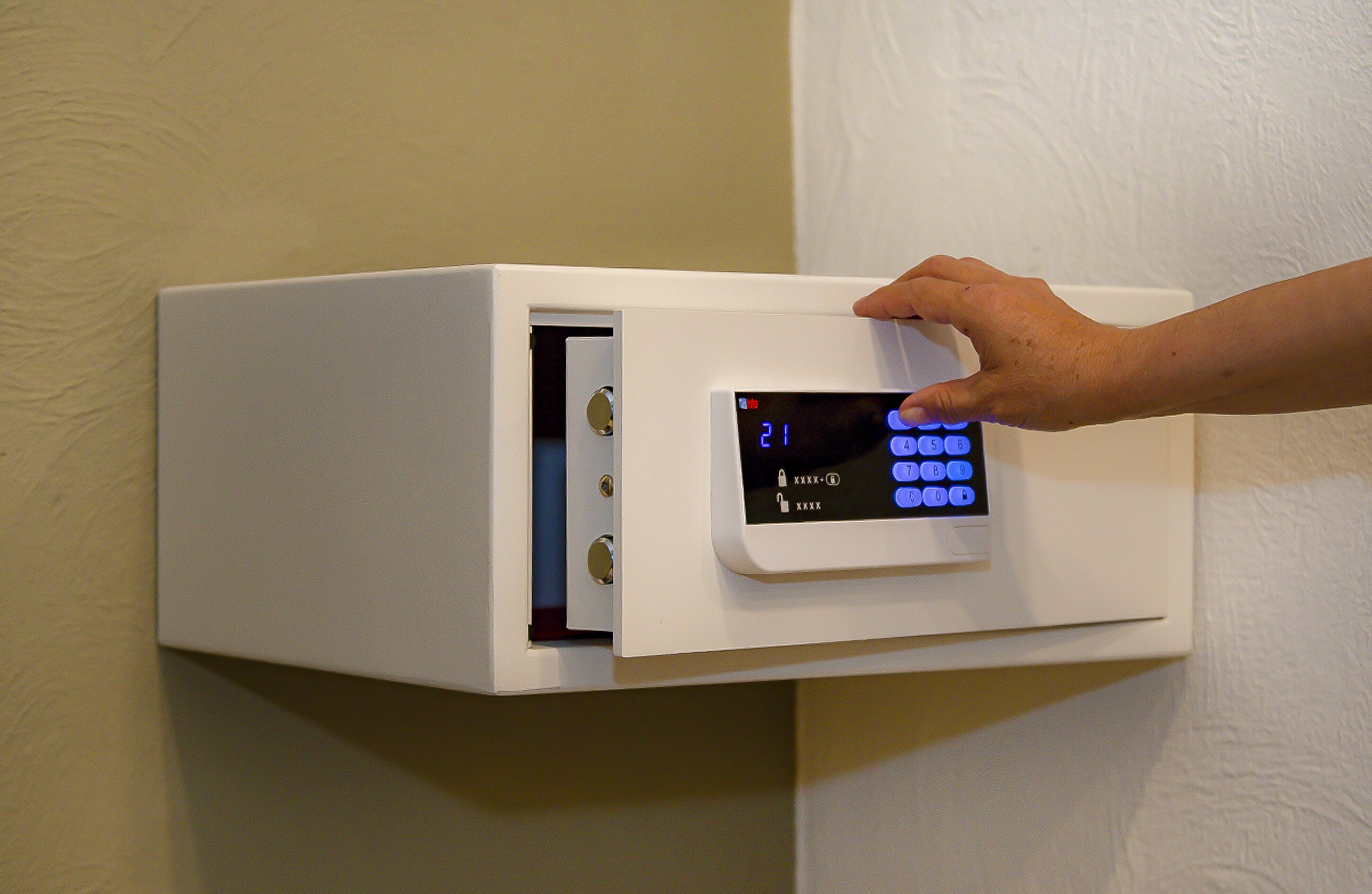 A wall-mounted electronic device with a keypad and a display screen.