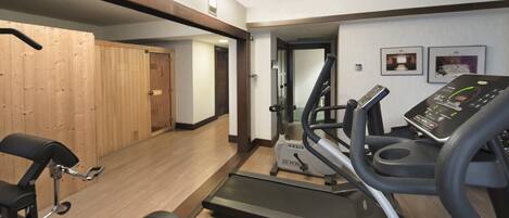 A gym with treadmills, a stationary bike, and a rowing machine.
