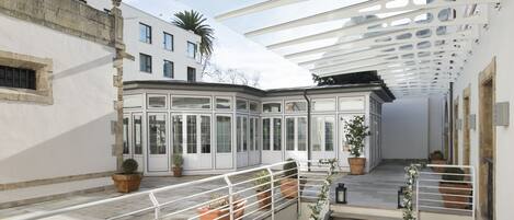 A spacious balcony with terracotta planters, a white railing, and a modern architectural design.