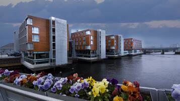 A modern building with a flat roof and large windows, situated next to a body of water.