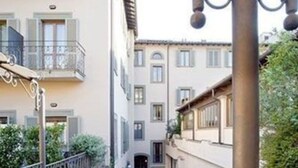 Un pati amb barana de balcó de ferro forjat, envoltat d'edificis amb balcons i finestres.