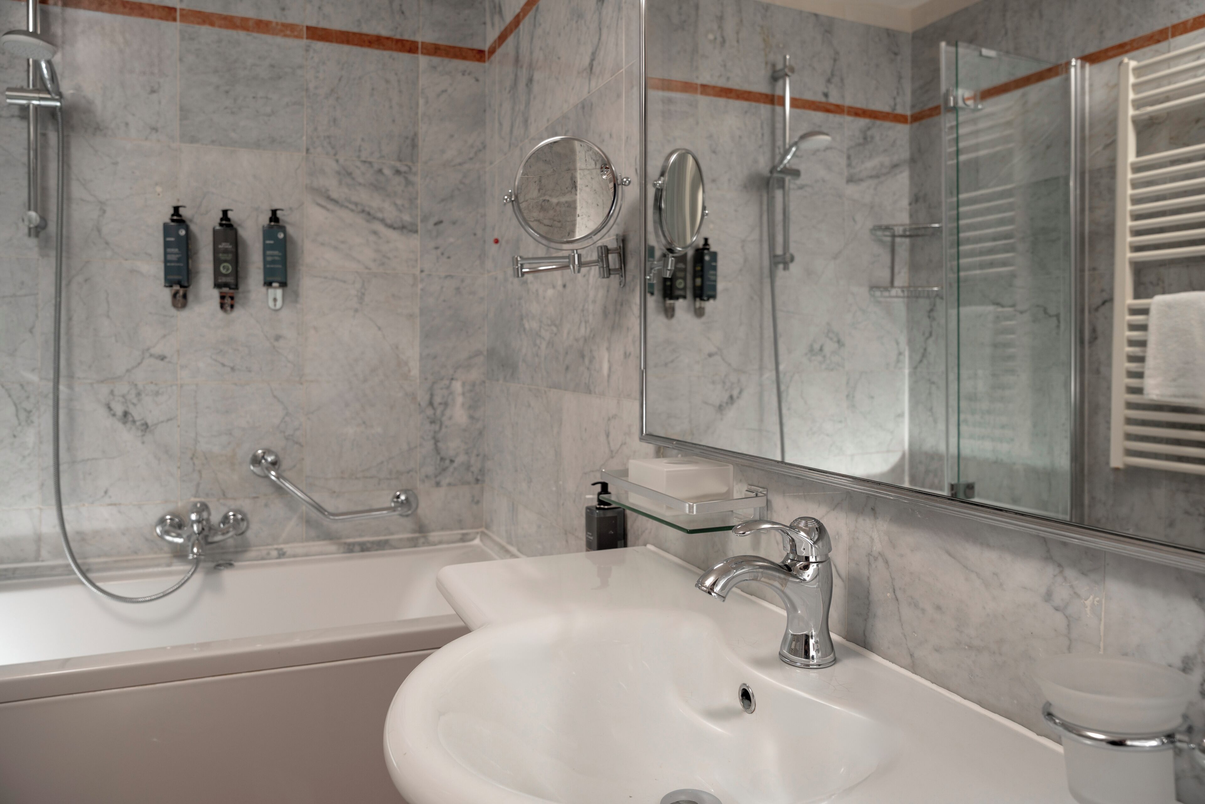A bathroom with a white sink, a glass shower enclosure, and a mirror.