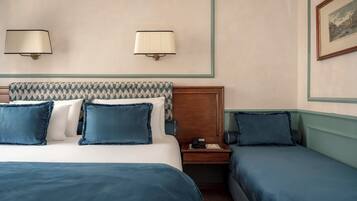 Una camera d'hotel con un letto, due comodini e una lampada a parete.