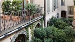 A multi-story building with balconies, arched windows, and a courtyard with greenery. - Hotel Adler Cavalieri (Florence)
