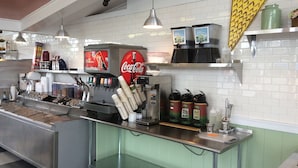 A beverage station with a Coca-Cola machine, ice dispensers, and a variety of drink options.