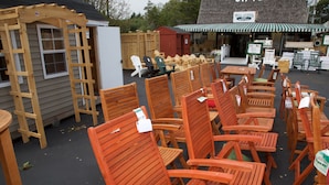 Outdoor wooden chairs and tables arranged in rows, likely for an outdoor seating area.