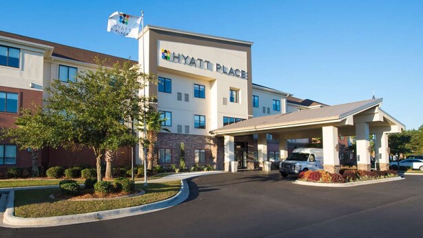 Un hôtel Hyatt Place doté d’une façade moderne, d’une entrée couverte et d’un mât pour drapeau.