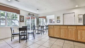 A spacious room with a kitchen area, dining tables, and chairs. - Best Western Mountain View Inn (Ellijay)