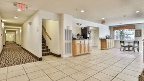 A spacious hotel lobby with a tiled floor, a staircase, a kitchen area, and a dining area. - Best Western Mountain View Inn (Ellijay)