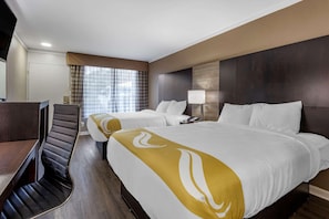 A hotel room with two beds, a desk, and a chair. - Baymont by Wyndham Pawleys Island (Pawleys Island)