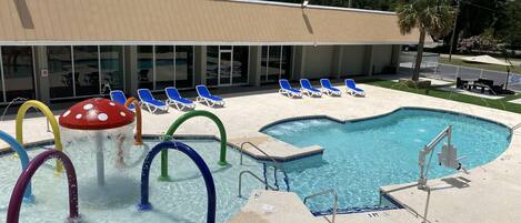 A swimming pool with colorful water slides and lounge chairs.