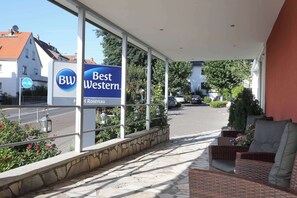 Ein Hotel Eingang mit einem Schild, das "BW Best Western Hotel Rosenau" zeigt, und Blick auf die Straße.