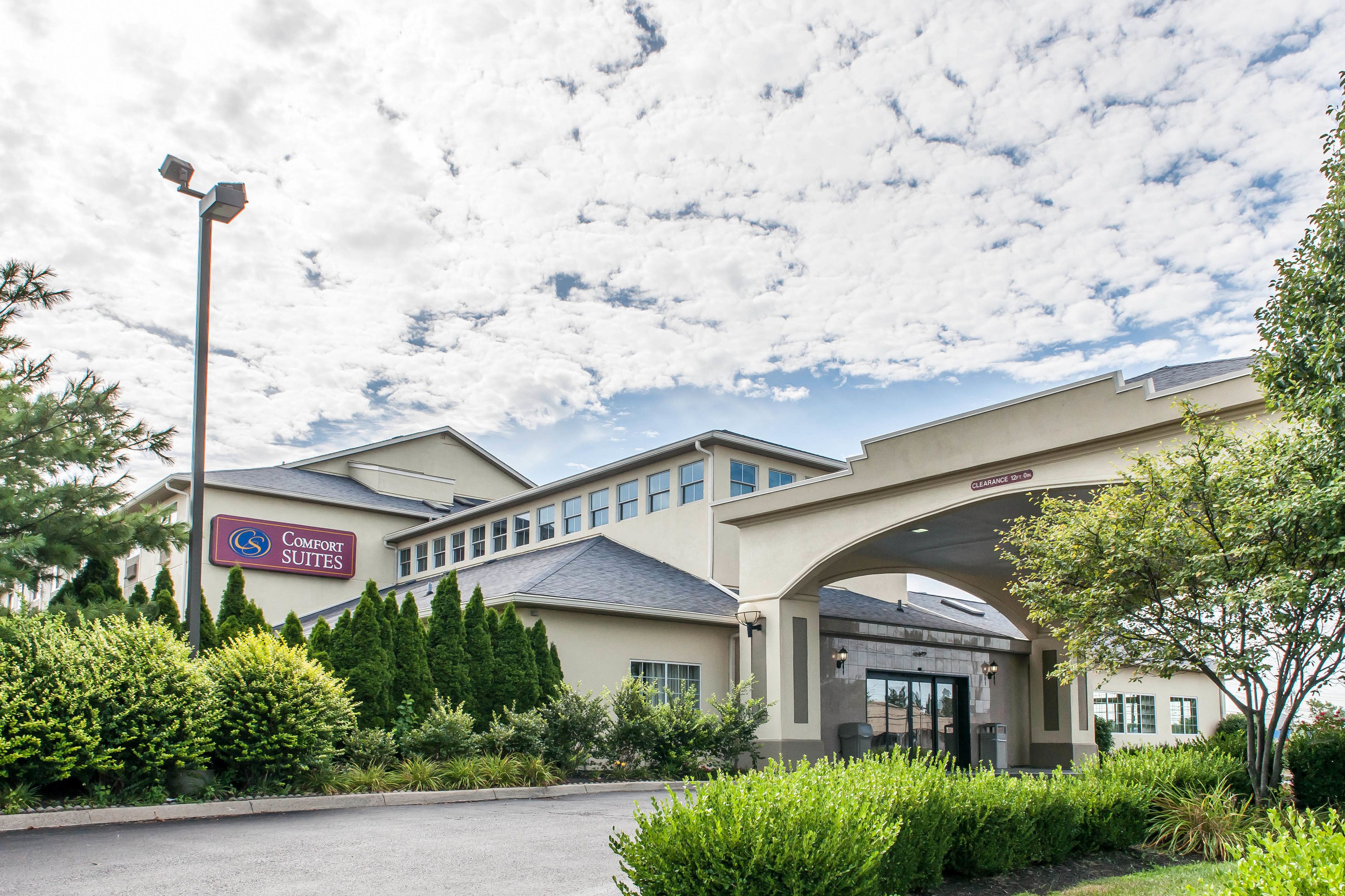 A hotel with a sign reading "Comfort Suites" and a covered entrance.