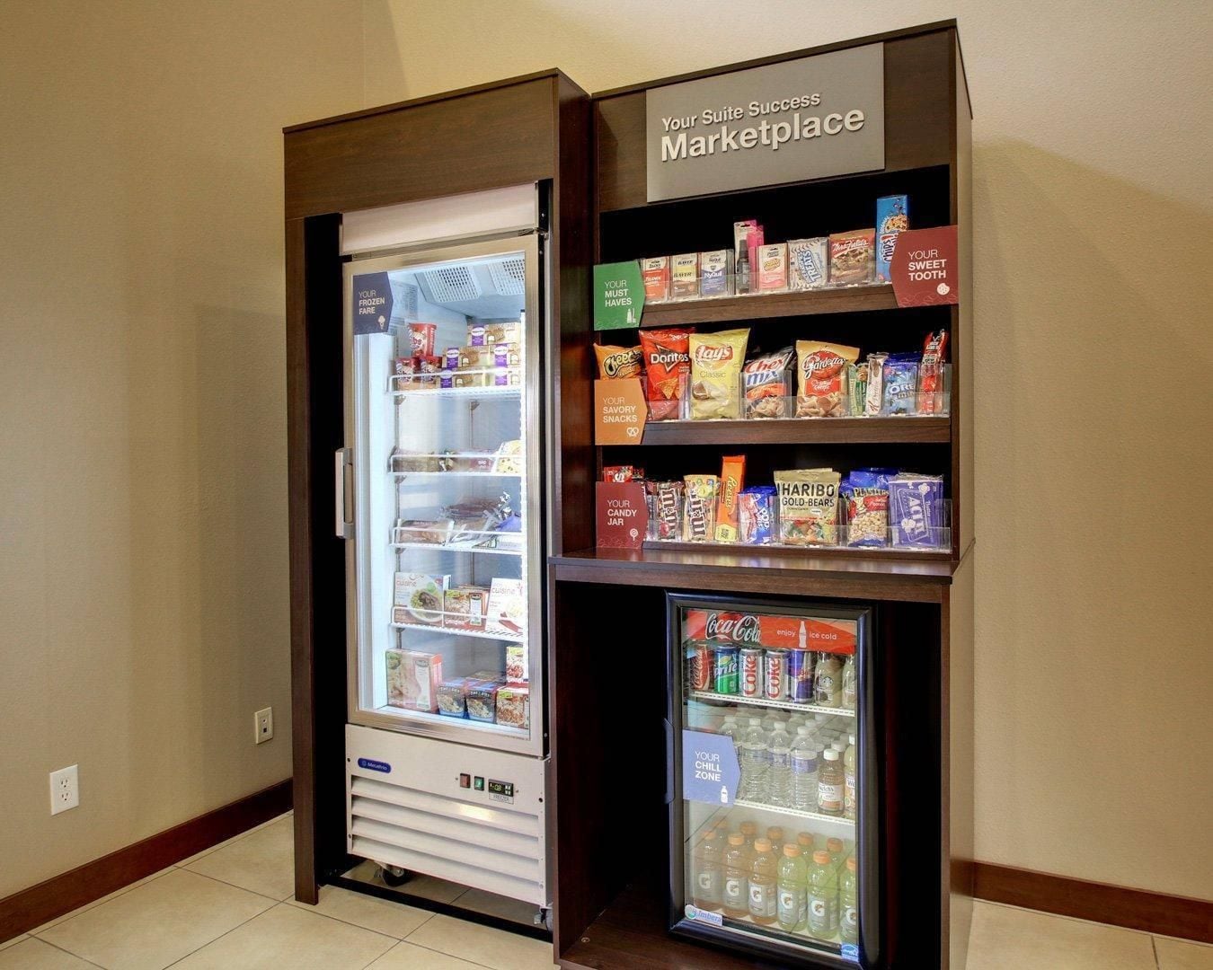 A vending machine with snacks and a Coca-Cola cooler.