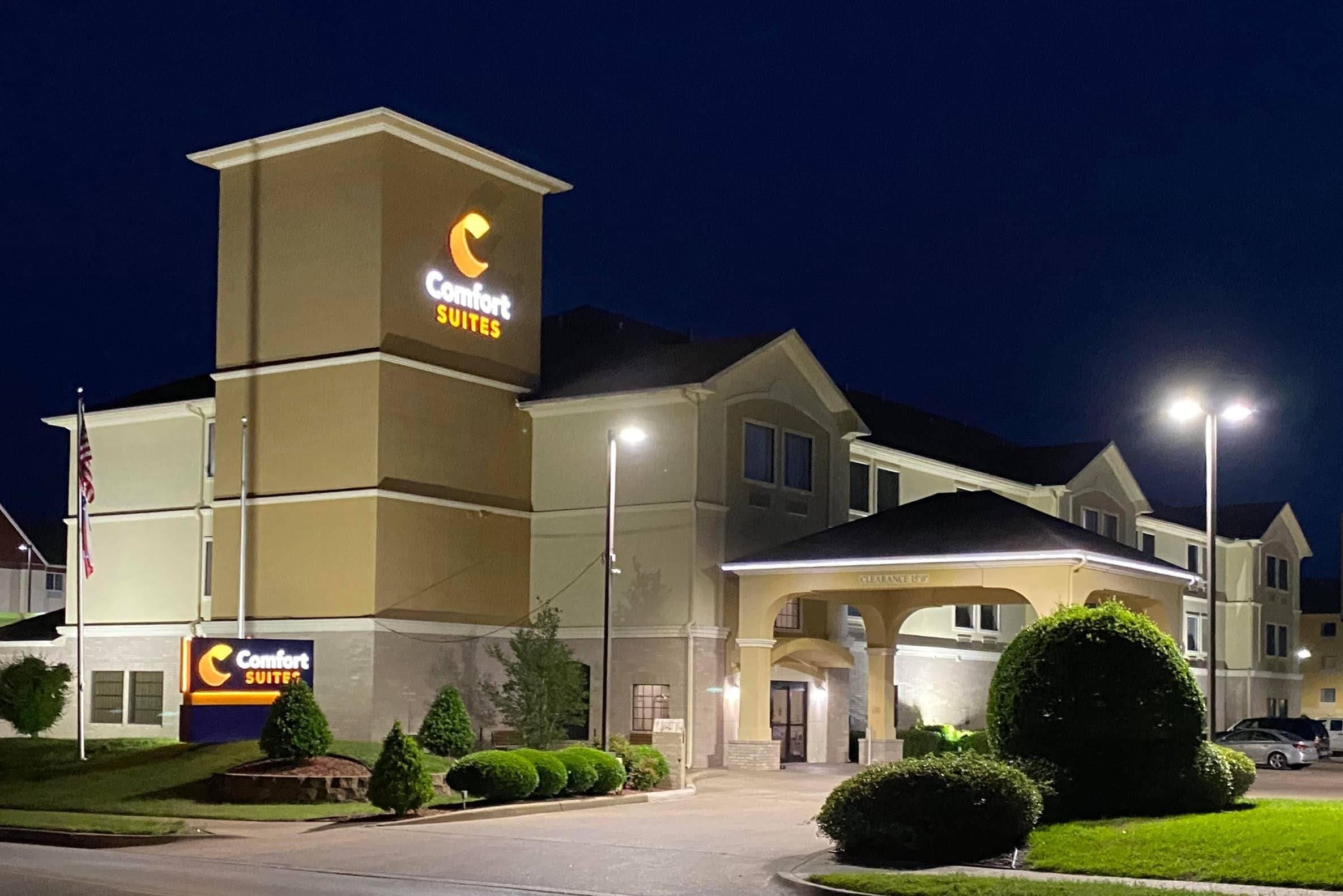 A Comfort Suites hotel with a prominent sign, a covered entrance, and well-maintained landscaping.