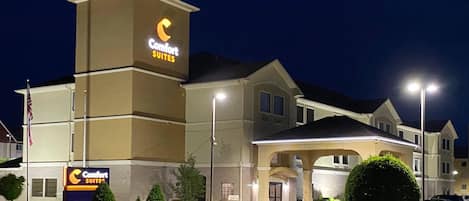 A Comfort Suites hotel with a prominent sign, a covered entrance, and well-maintained landscaping.