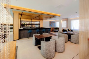 Zona de bar moderna con asientos y una barra.
