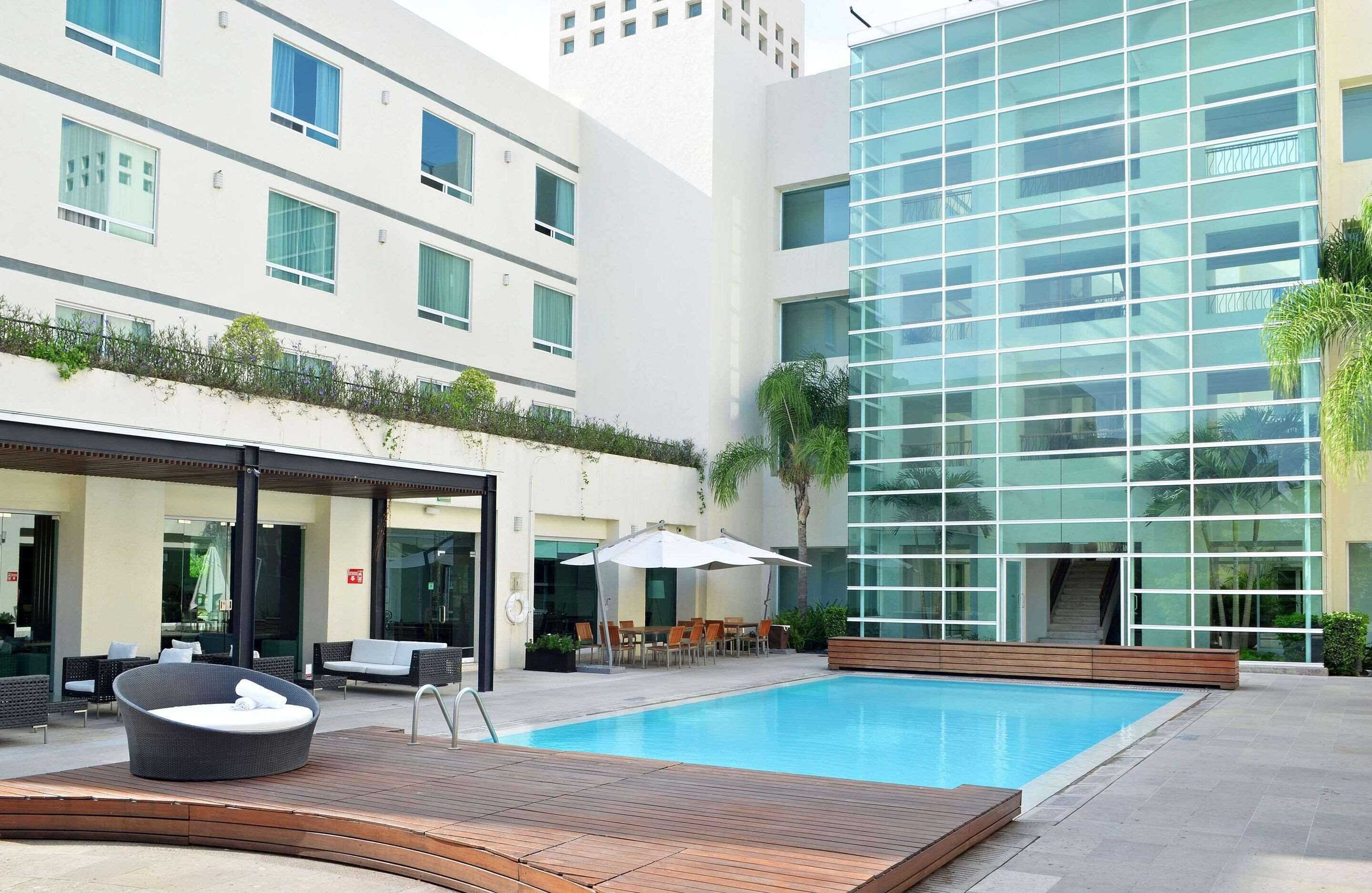 Una piscina al aire libre, tumbonas