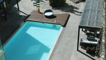 Alberca al aire libre y camastros