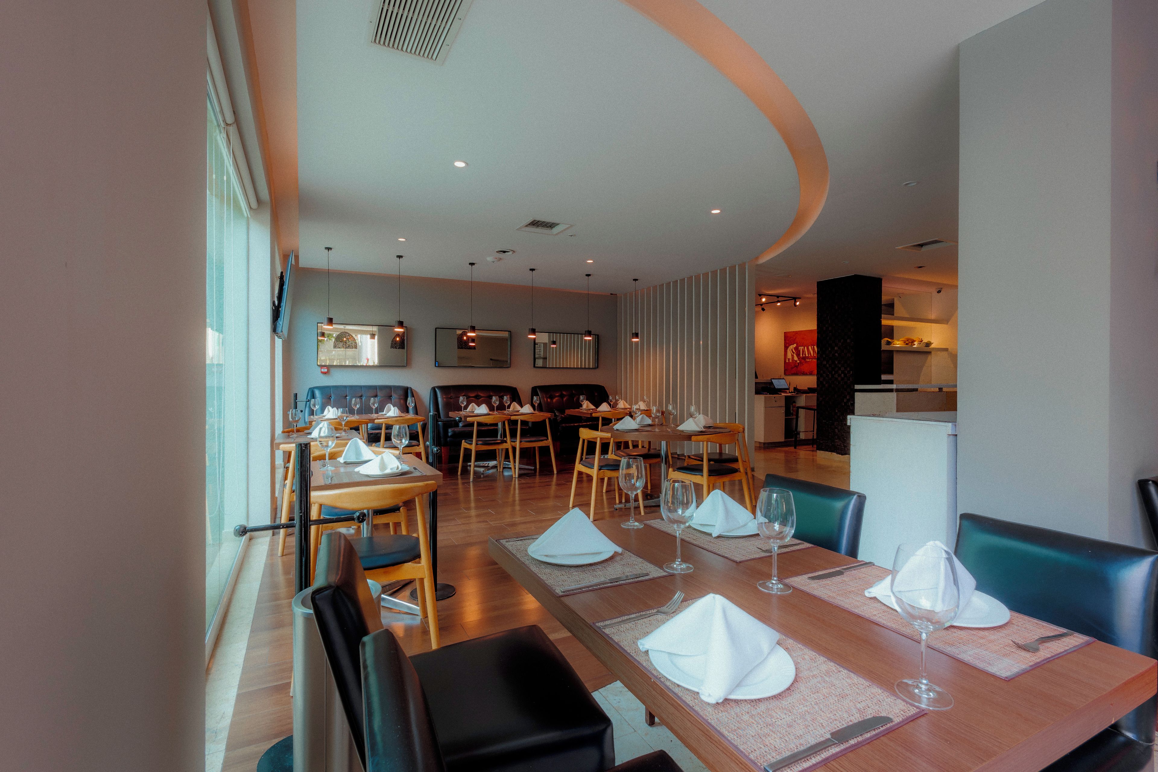 A restaurant with multiple dining tables, chairs, and a modern interior design.