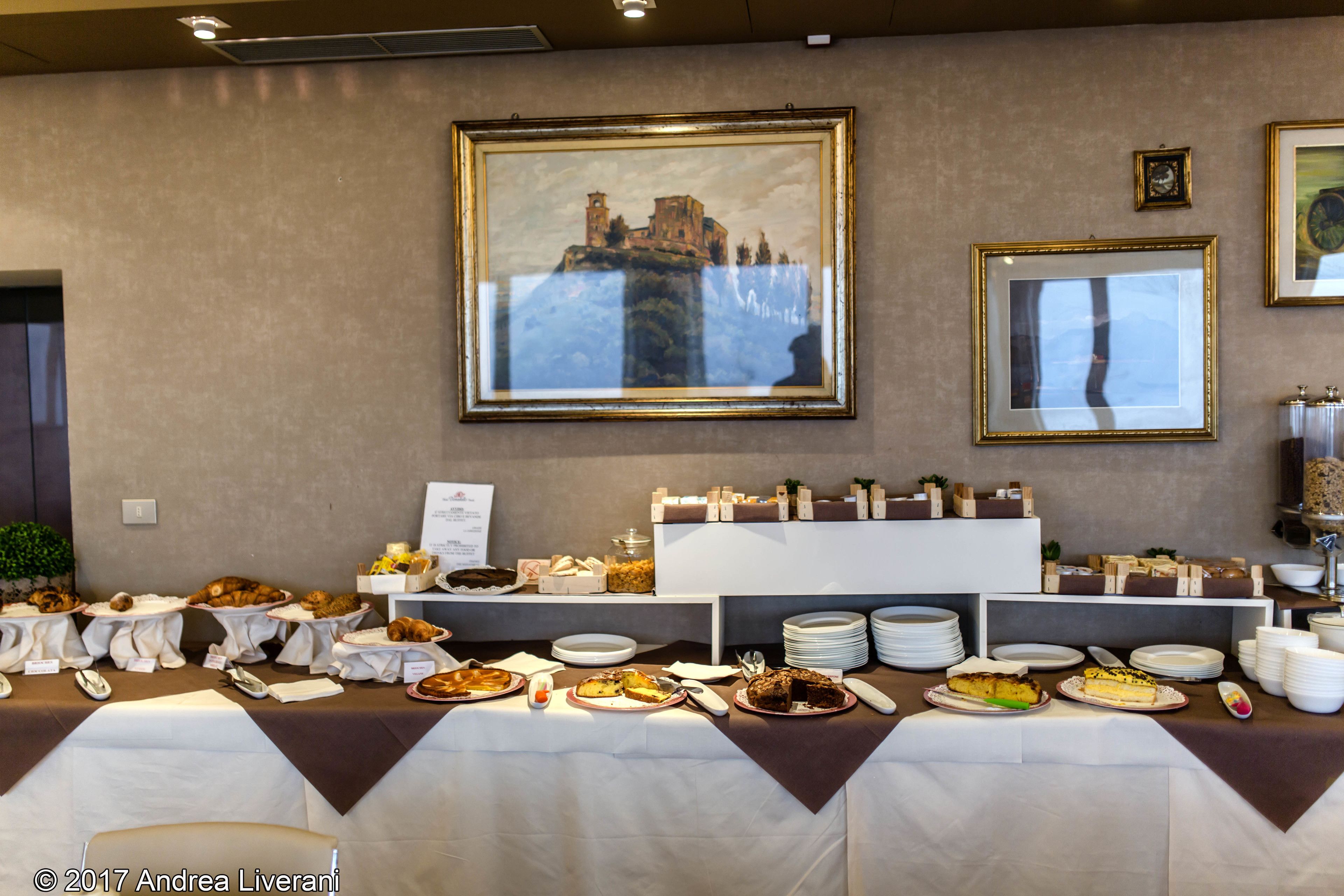 Ein reichhaltiges Buffet mit verschiedenen Speisen und ein großes gerahmtes Gemälde an der Wand.