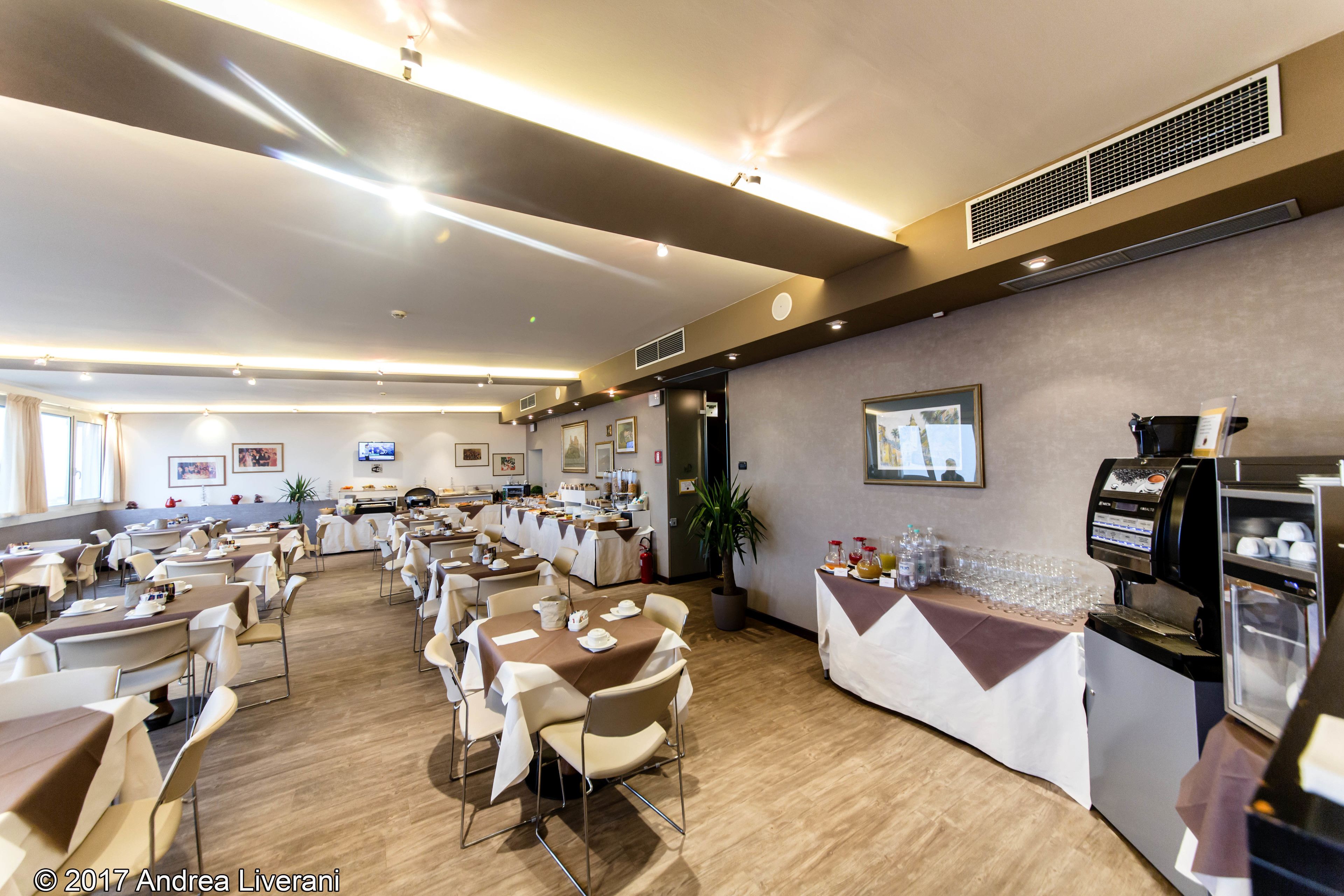 A spacious dining area with multiple tables and chairs, a coffee machine, and a buffet counter.