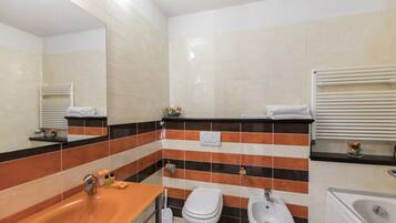 Ein Badezimmer mit Waschbecken, Toilette, Bidet und Badewanne.