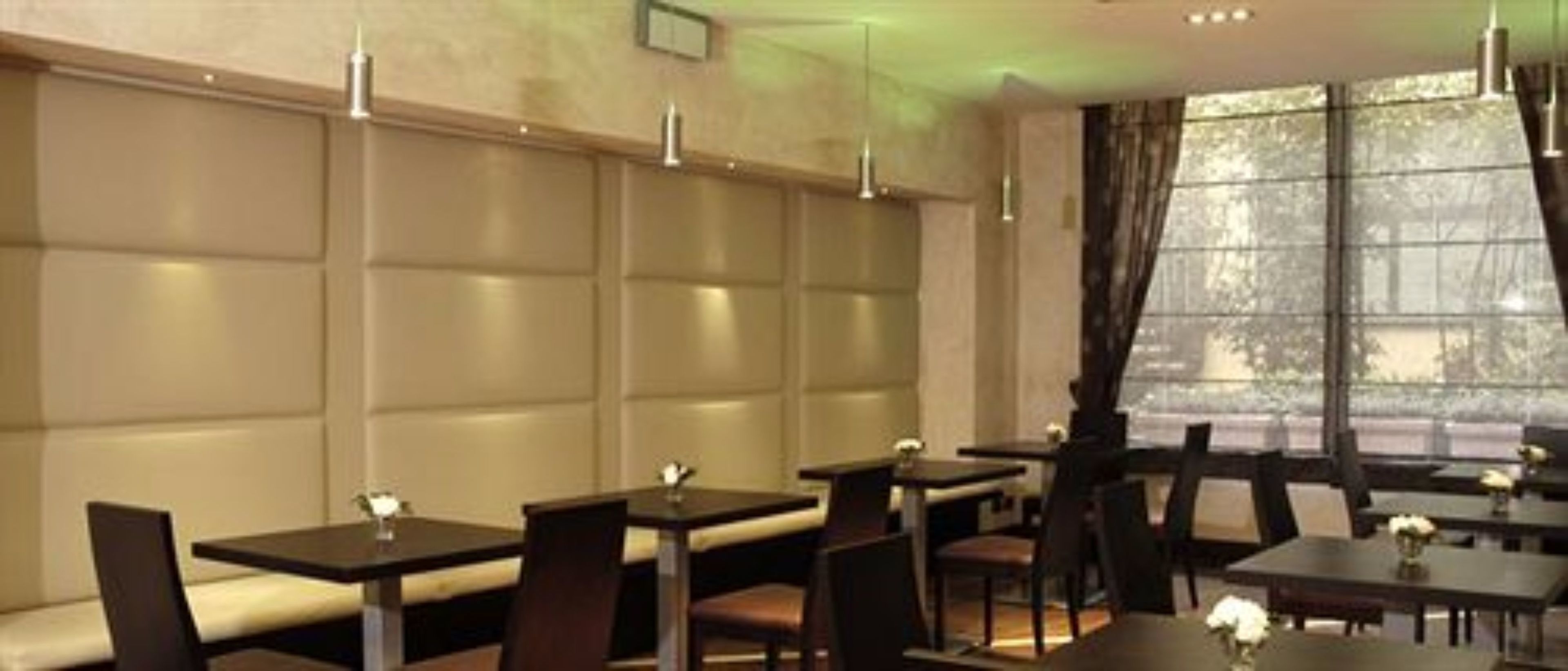 A restaurant with booth seating, pendant lighting, and a view of the outdoors.