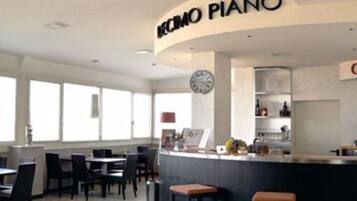 Un caffè moderno con un pianoforte, tavoli e sedie.