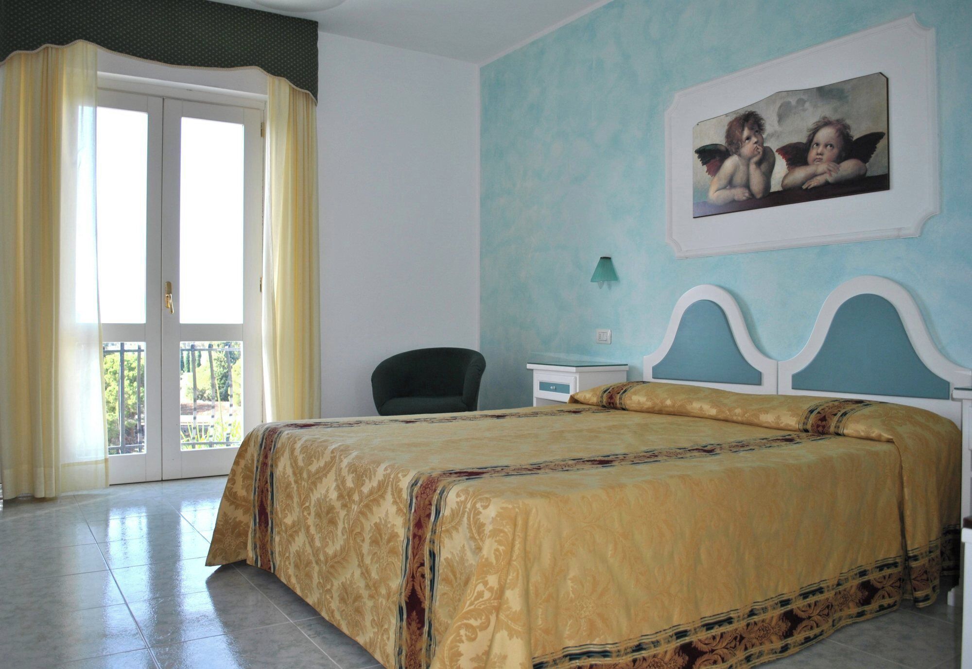 A bedroom with a bed, a chair, a nightstand, and a painting on the wall.