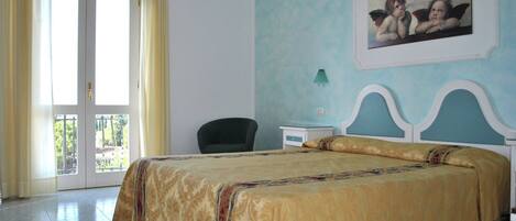 A bedroom with a bed, a chair, a nightstand, and a painting on the wall.