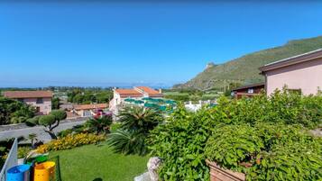 Zona residenziale con case, una montagna sullo sfondo e cielo sereno.