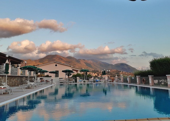 Una piscina al aire libre, cabañas de piscina gratuitas, sombrillas