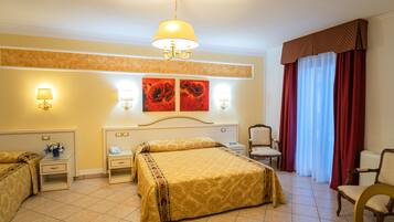 Camera d'albergo con un letto, due comodini, una sedia, una scrivania e un'ampia finestra con tende.