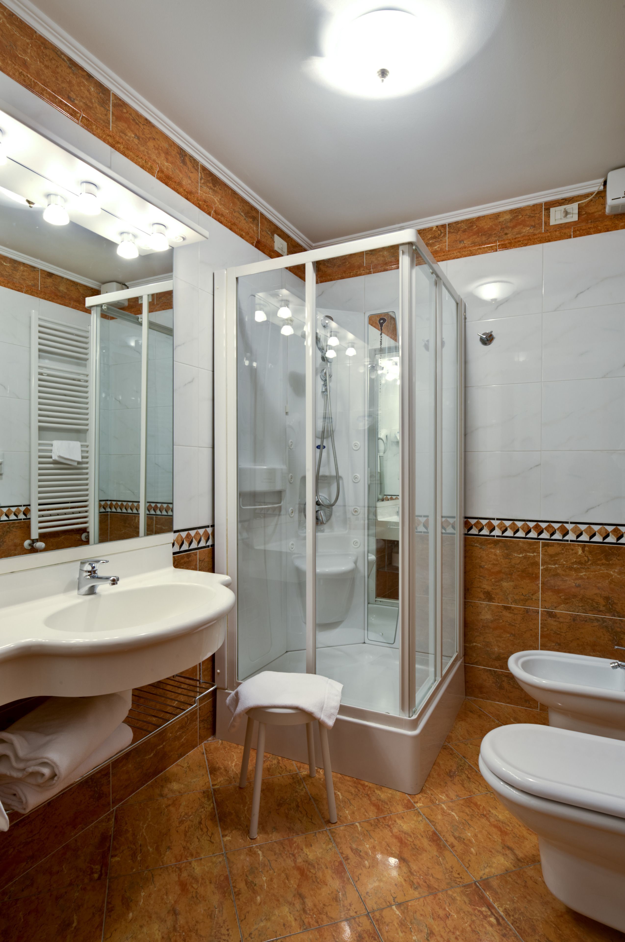 Une salle de bain moderne avec une douche à parois de verre, un lavabo et des toilettes.