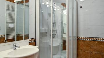 Une salle de bain moderne avec une douche à parois de verre, un lavabo et des toilettes.