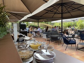 Relax under shaded umbrellas and enjoy a variety of seating options amidst lush surroundings.