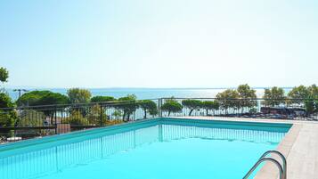Een seizoensgebonden buitenzwembad, parasols voor strand/zwembad