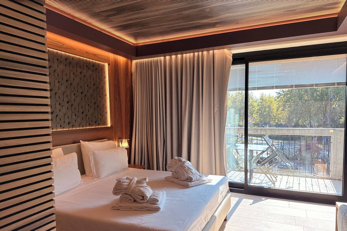 Ein Hotelzimmer mit Bett, einem großen Fenster und Blick ins Freie.