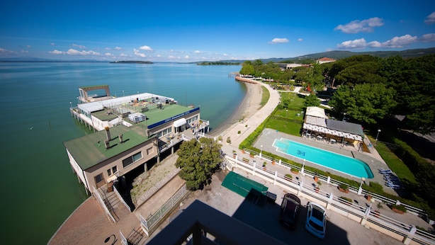 Un hotel frente al agua con piscina, muelle para barcos y vistas al mar.