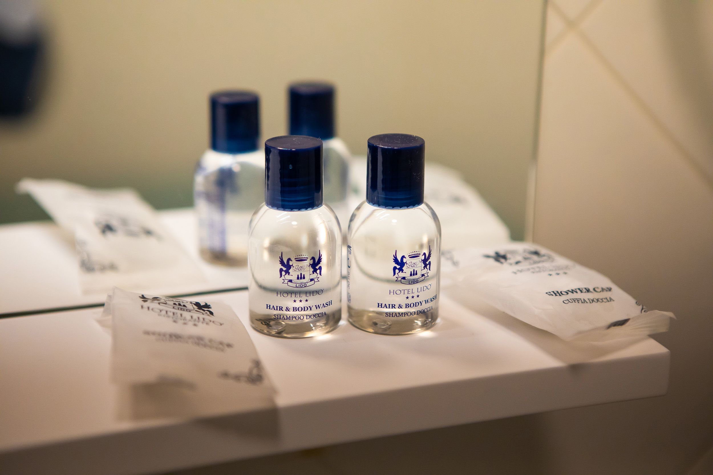 Eine Präsentation der Ha- und Körperpflegeprodukte von Hotel Lido auf einer weißen Theke.