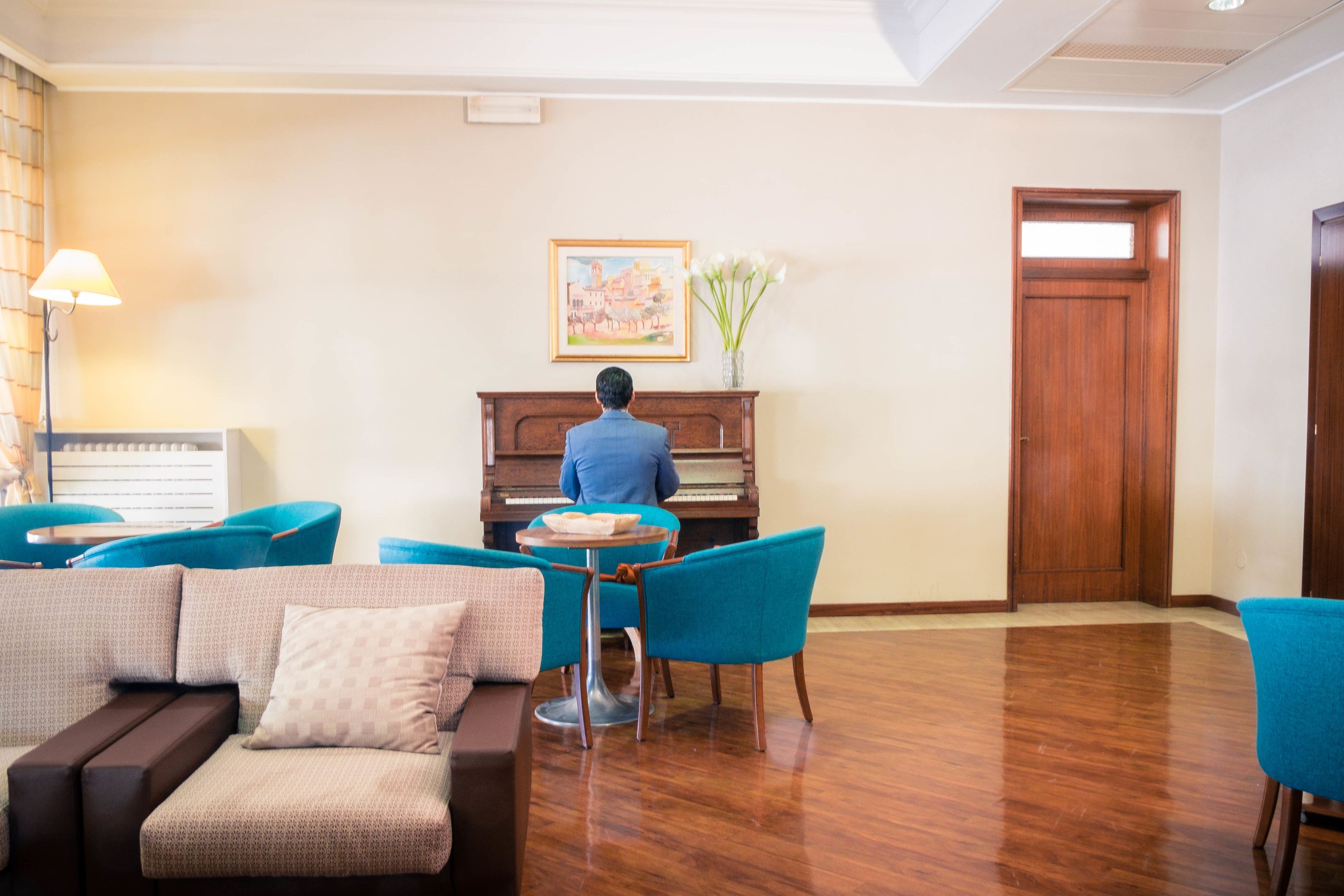 Une pièce avec un piano, un canapé et une table avec des chaises.