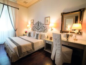 A hotel room with a bed, bedside tables, a desk, a chair, a mirror, and a window with curtains. - Hotel Jolanda (Santa Margherita Ligure)