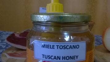 Un vasetto di miele toscano con un erogatore giallo.