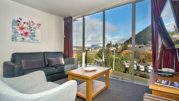 Deluxe One Bedroom Apartment | Living area | Flat-screen TV, DVD player