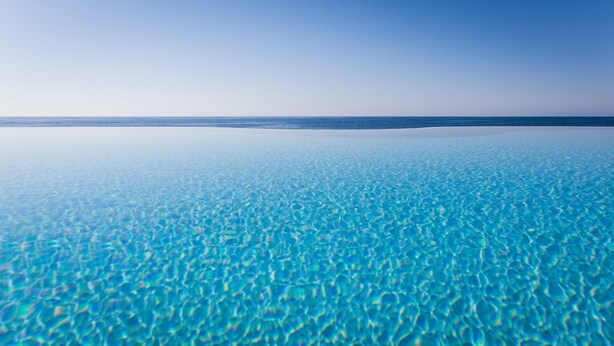 A clear view of a beach with shallow water and a distant horizon. - Hotel Costa Dei Fiori (Pula)