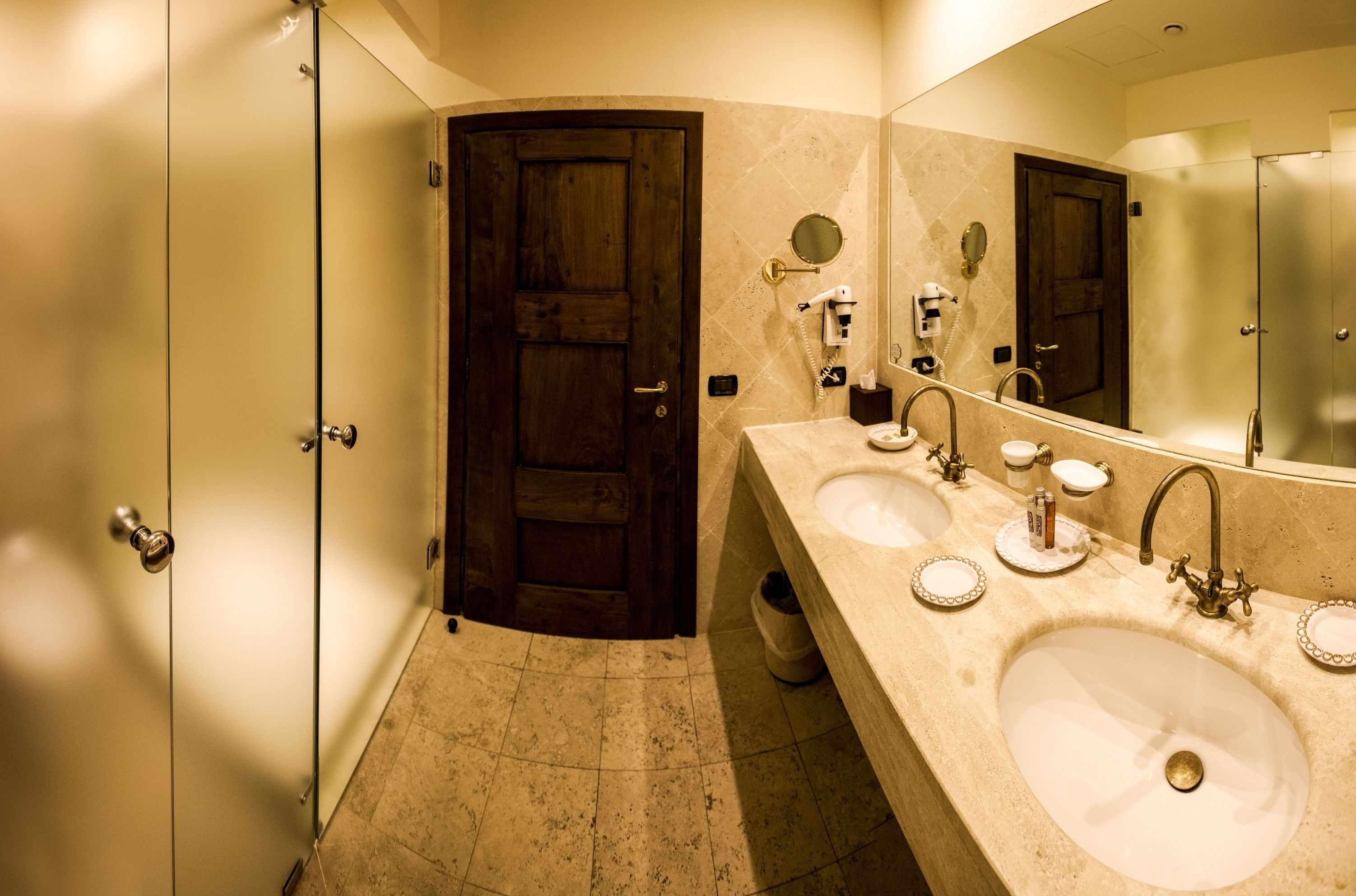 A bathroom with two sinks, a large mirror, and a wooden door.