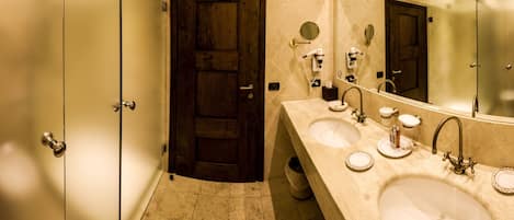 A bathroom with two sinks, a large mirror, and a wooden door.