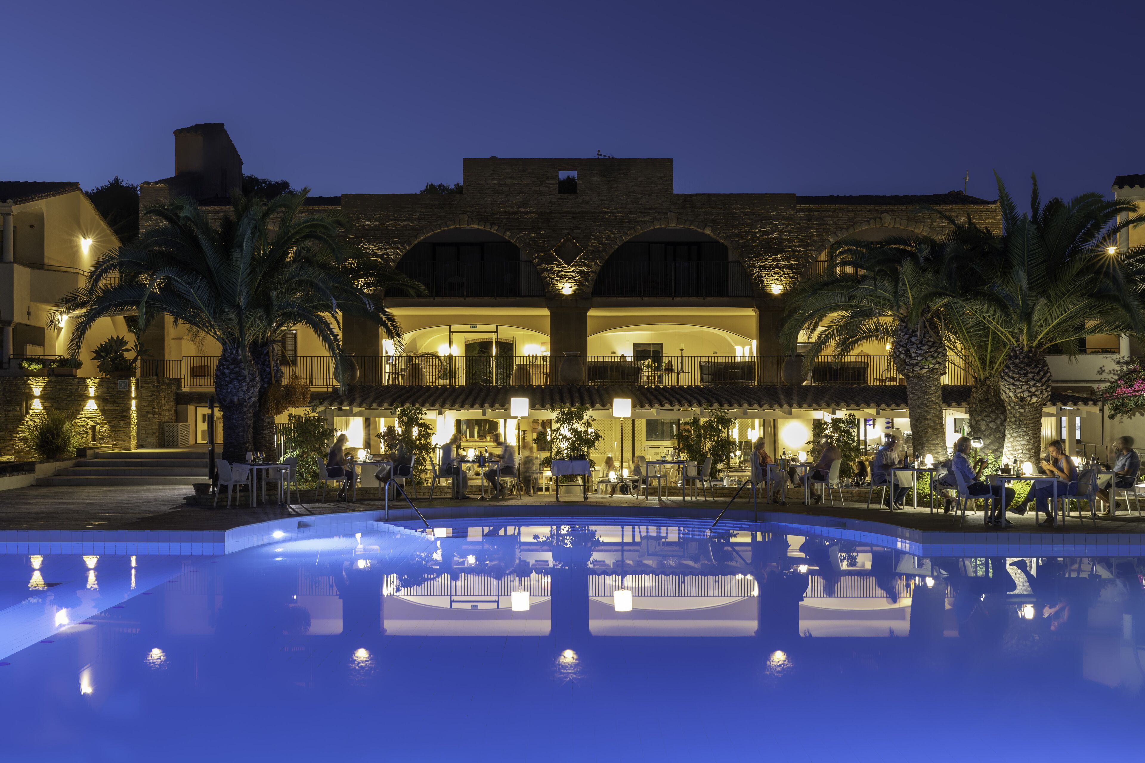 Ein Hotel mit Pool, Außenbereich und einer Steinaußenwand.