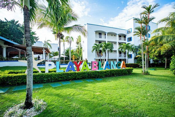 A hotel with a sign reading 'AYABLANCA' surrounded by lush greenery and palm trees. - Playa Blanca Beach Resort - All Inclusive (Rio Hato)